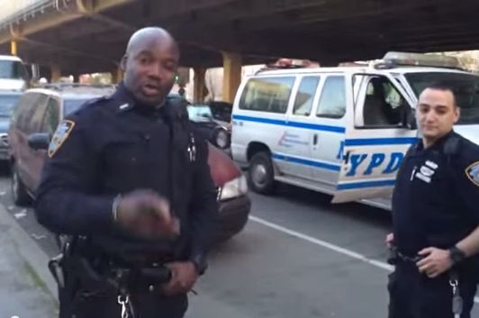 Two officers backing away from an unlawful bag search in May, while being filmed by NYPD videographer Shawn Thomas